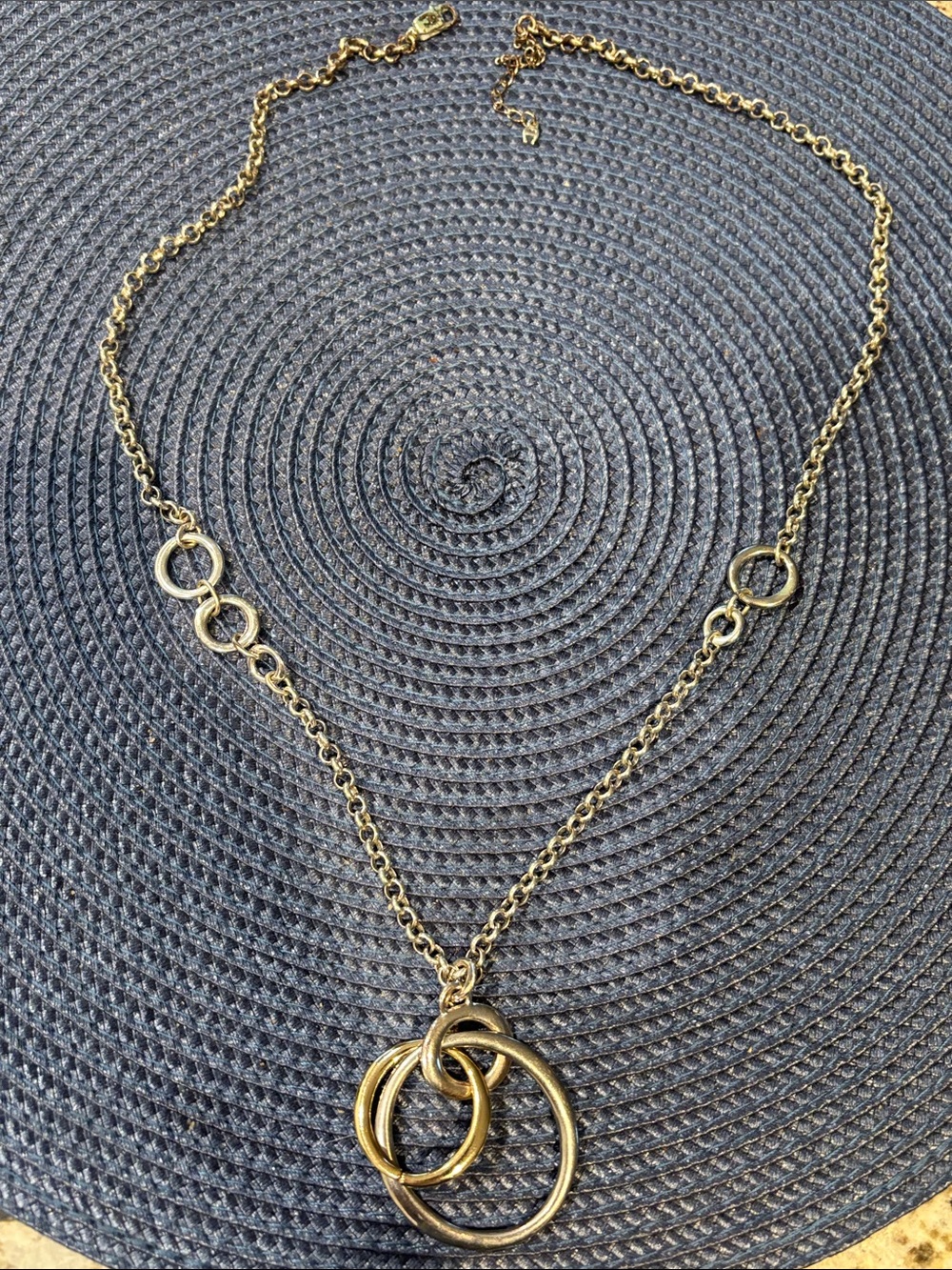A mixed-metal, interlocking multi-ring pendant necklace from Etienne Aigner